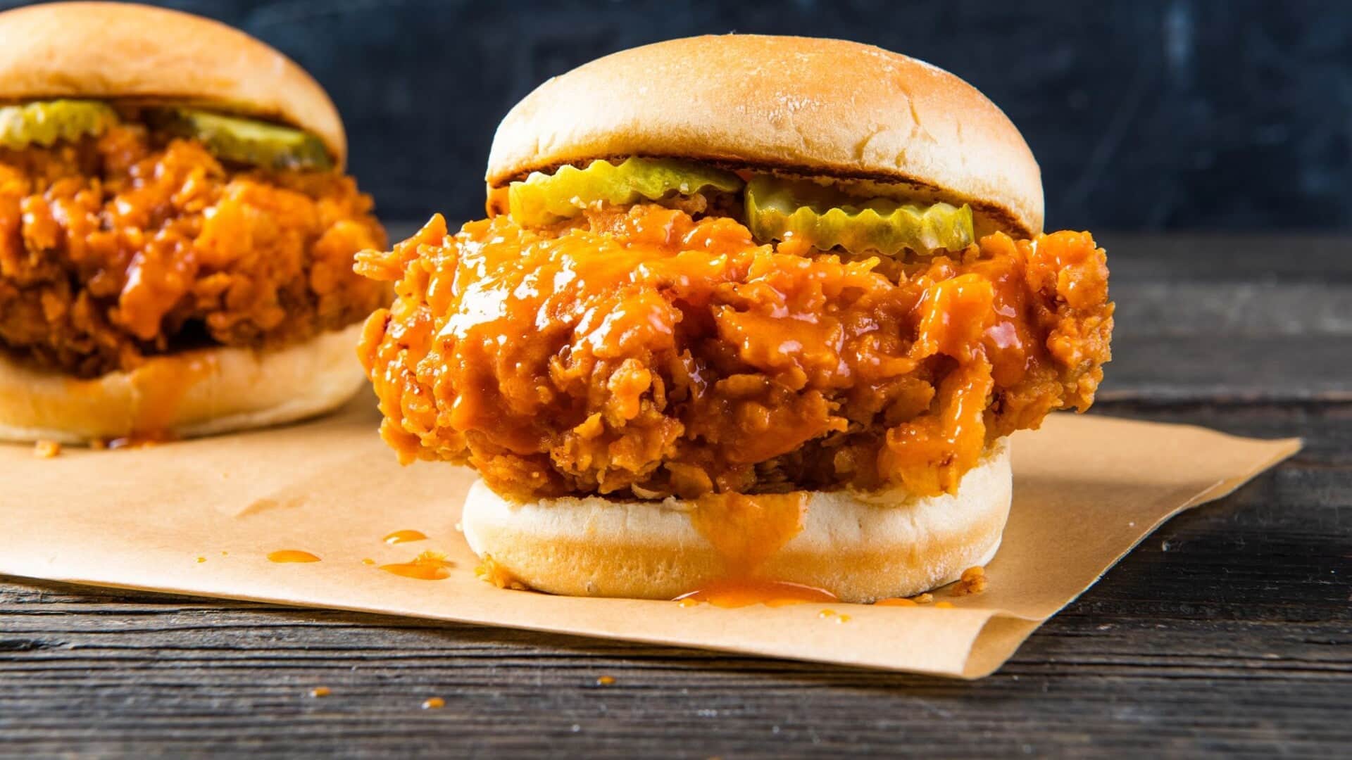 Two Nashville crispy chicken burgers with pickles on paper